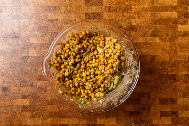a large glass bowl filled with mexican street corn salad.