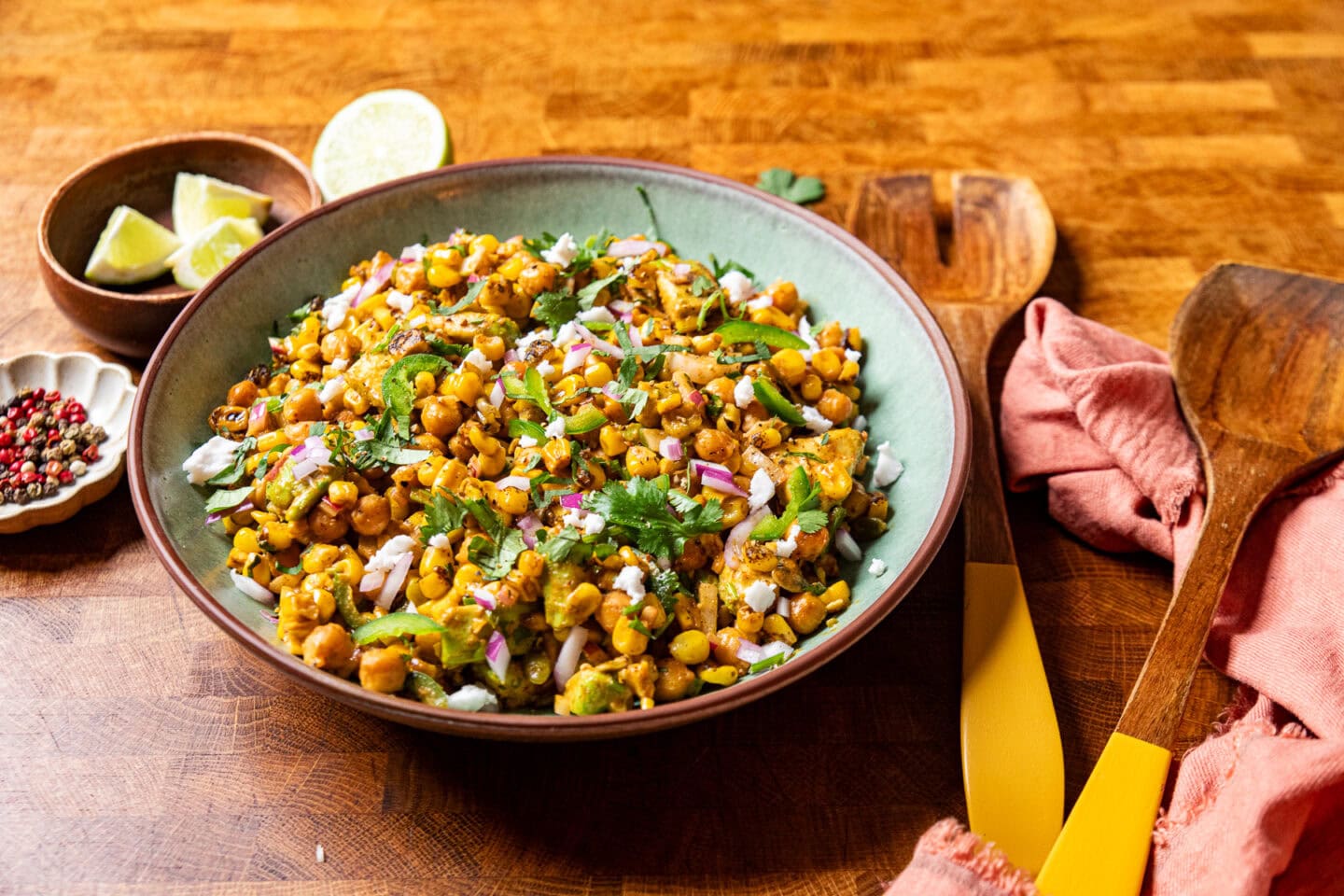 chickpea elote salad in a green bowl on a table.