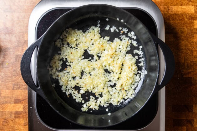 onions and garlic sauteing in a cast iron skilet.