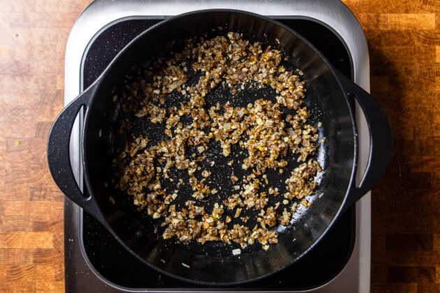 dried spices and onions sauteing in a cast iron skilet.