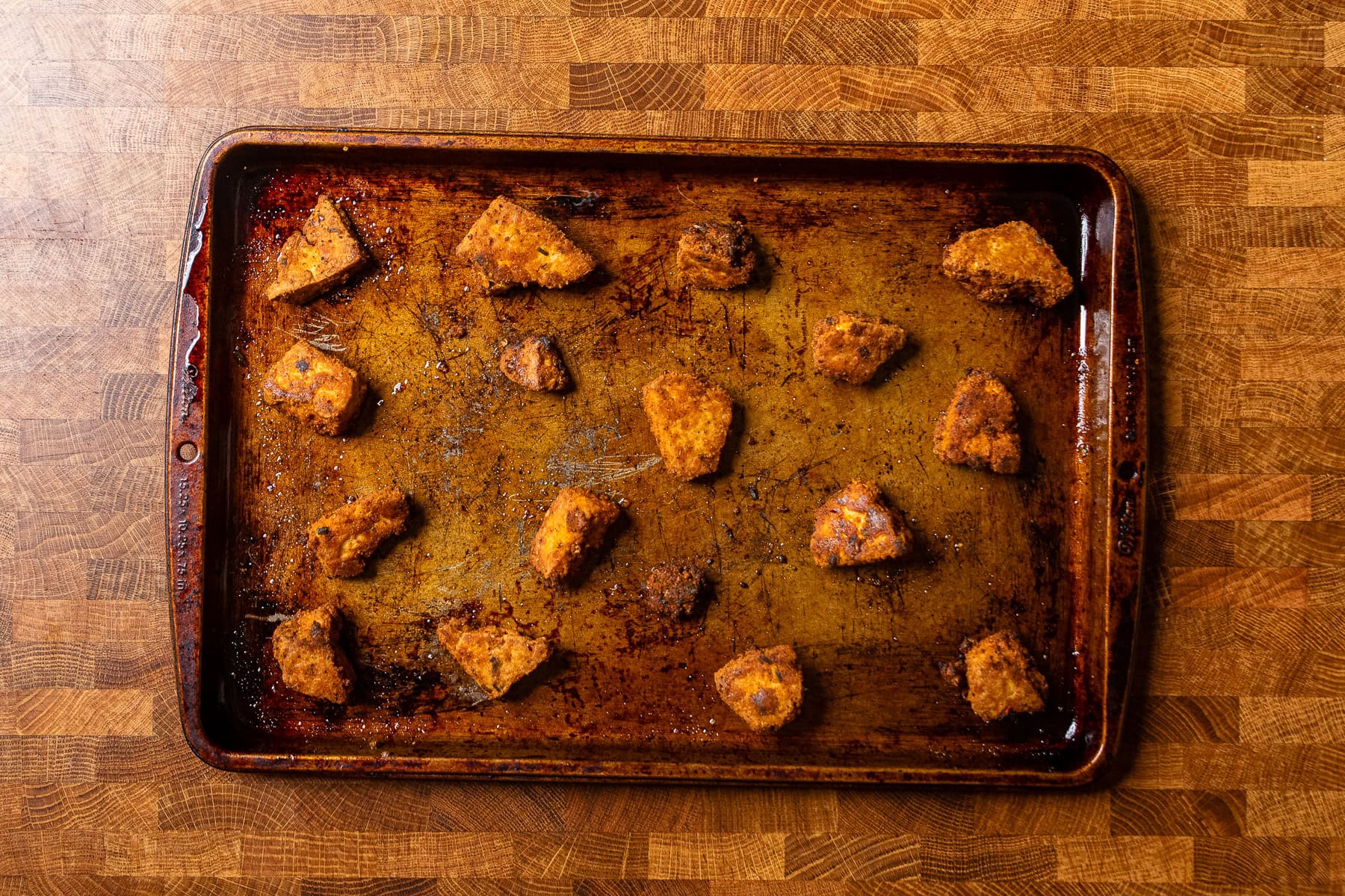 cooked crispy tofu pieces on a baking tray.