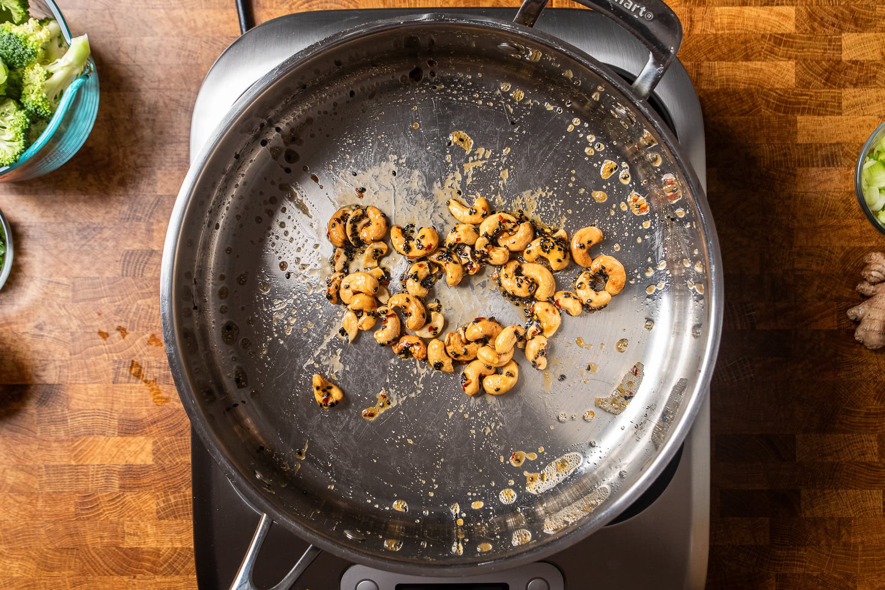 maple sesame cashews in a skillet cooking.