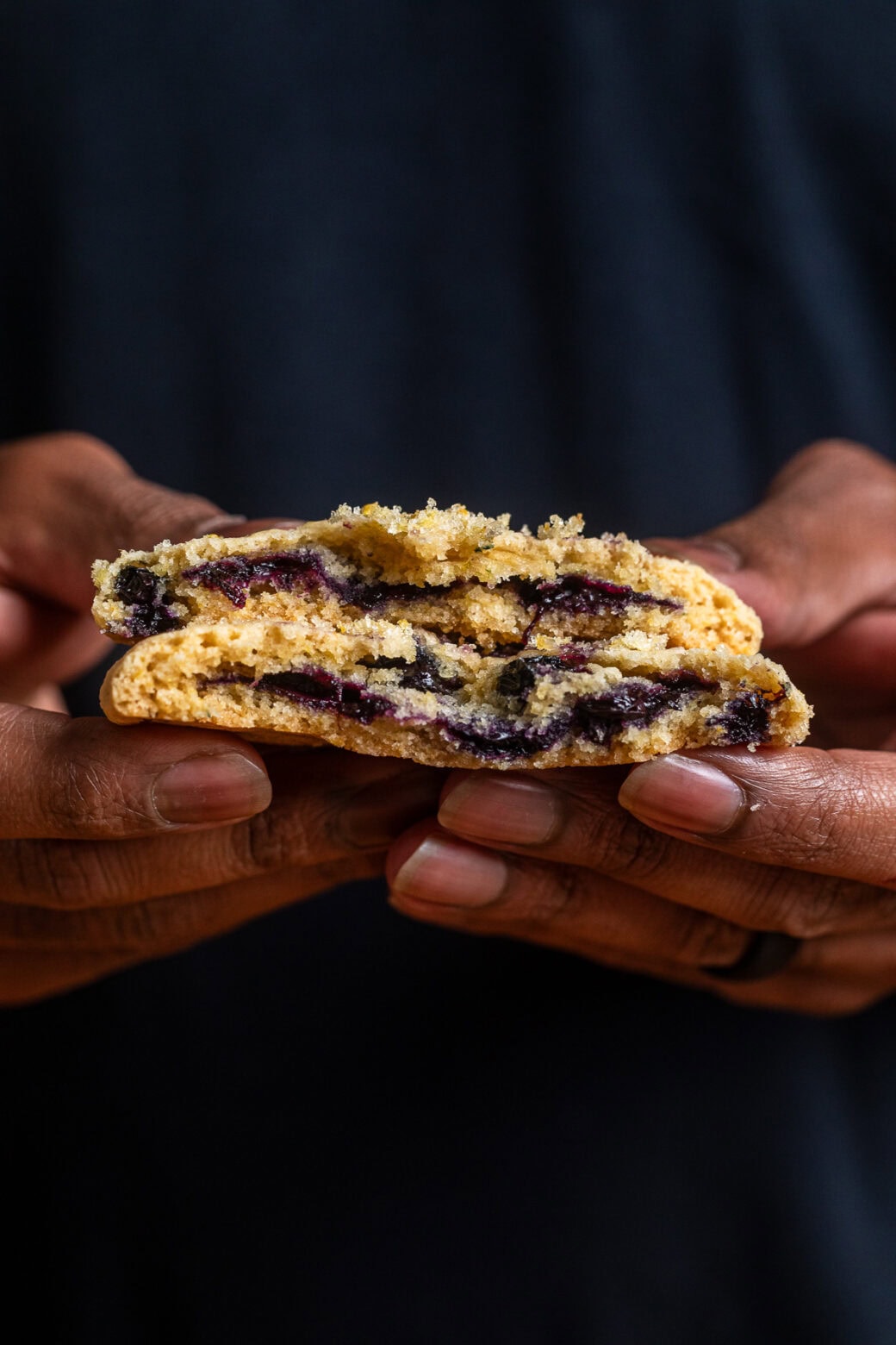 a lemon blueberry cookie broken in half to see the creamy blueberry filling inside.