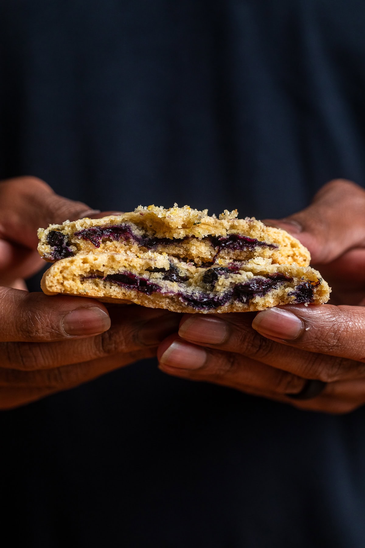 a lemon blueberry cookie broken in half to see the creamy blueberry filling inside.