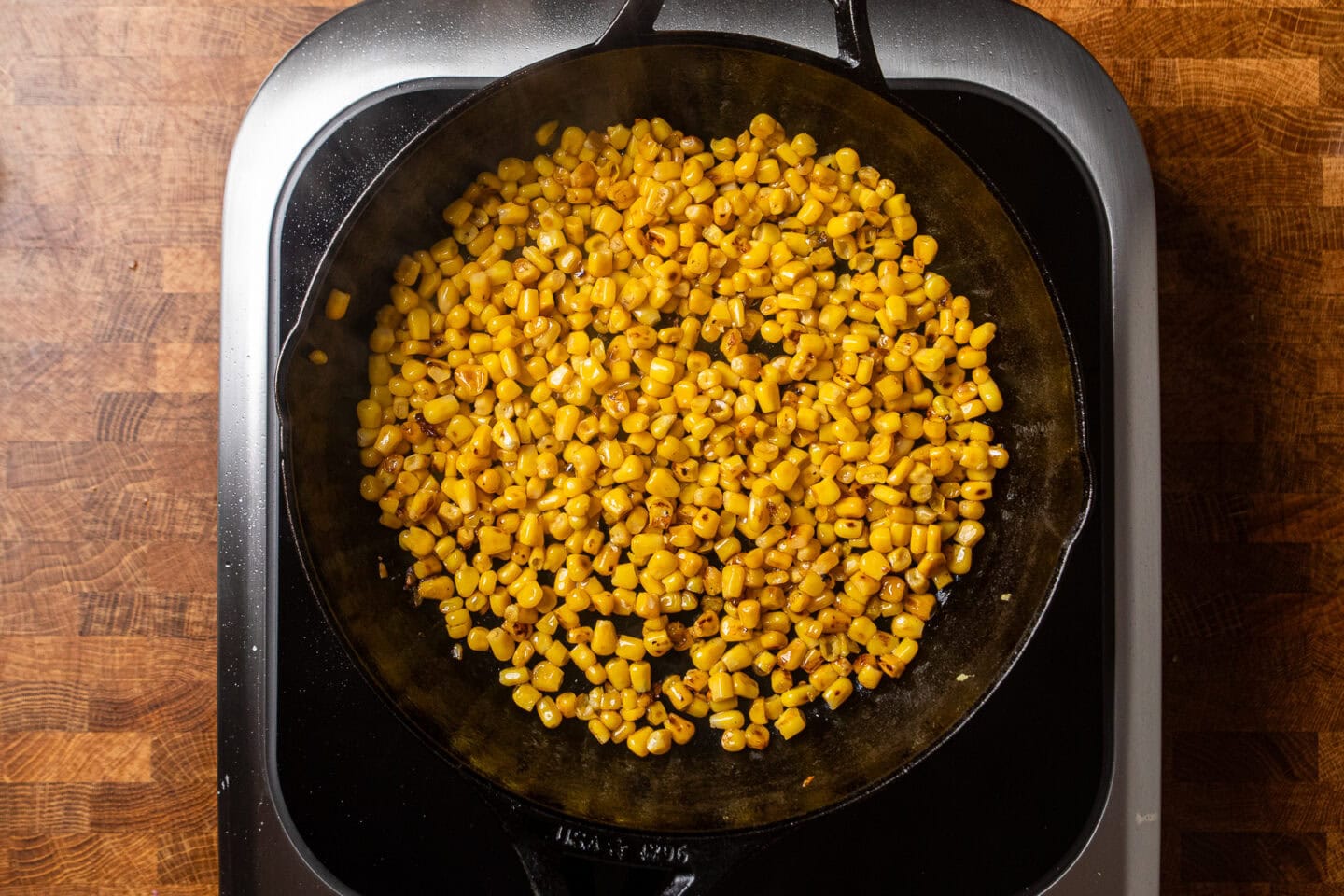 charred corn kernels in a cast iron skillet.