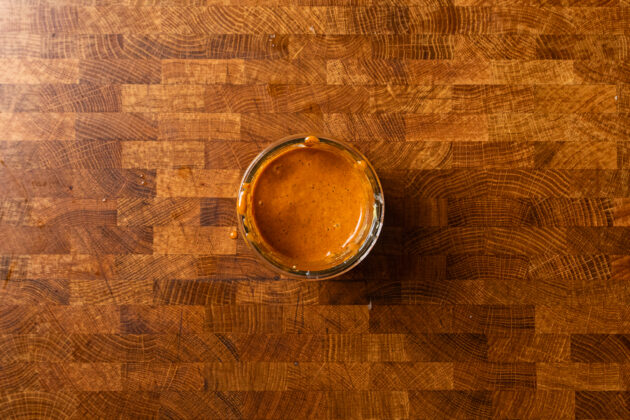 an orange southwest dressing in a glass jar on a table.