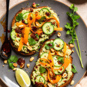 two slices of edamame toast with carrot ribbons, sliced baby cucumbers and chili crunch.