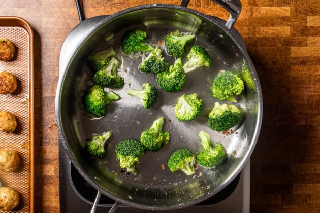 broccoli charring in a stainless steel skillet.