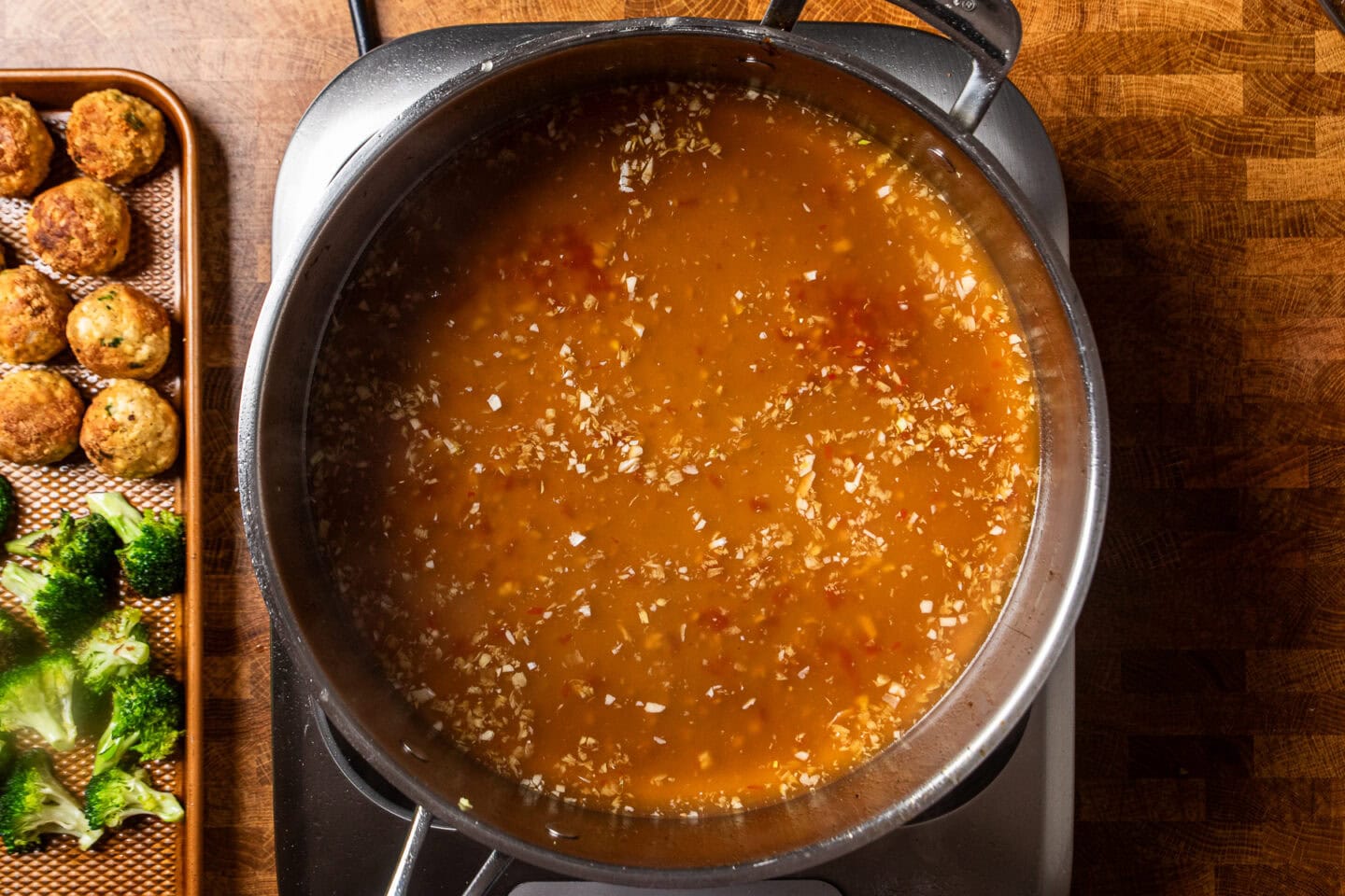sweet chili sauce cooking in a stainless steel skillet.