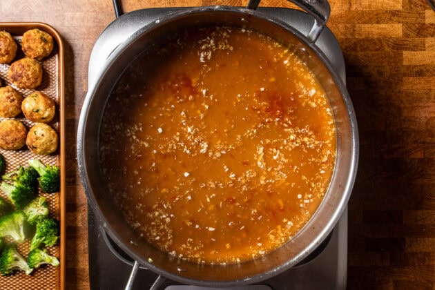 sweet chili sauce cooking in a stainless steel skillet.