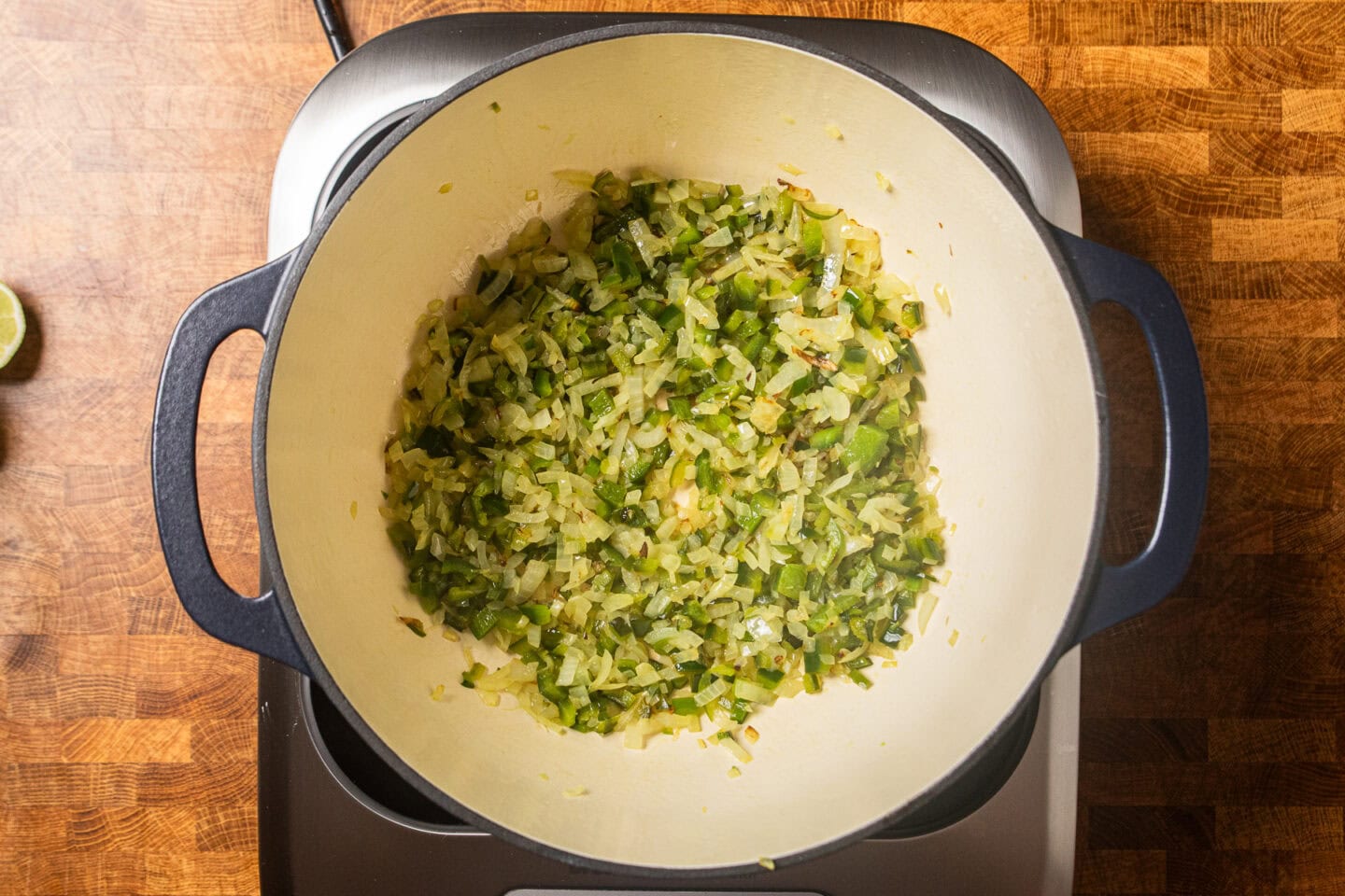 onions, peppers, and garlic sauteing in a dutch oven.