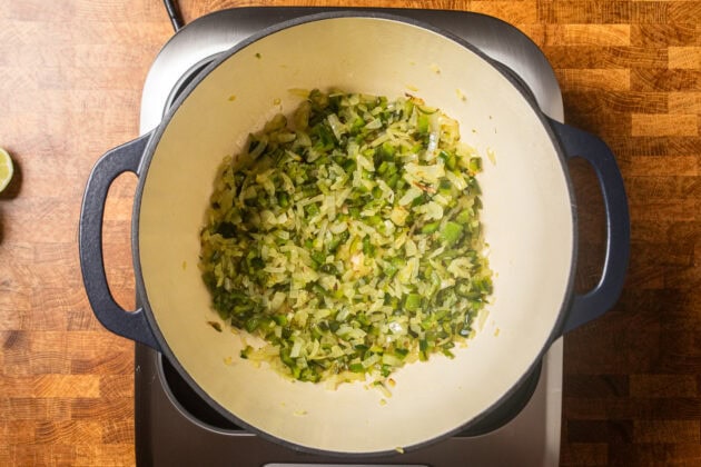 onions, peppers, and garlic sauteing in a dutch oven.