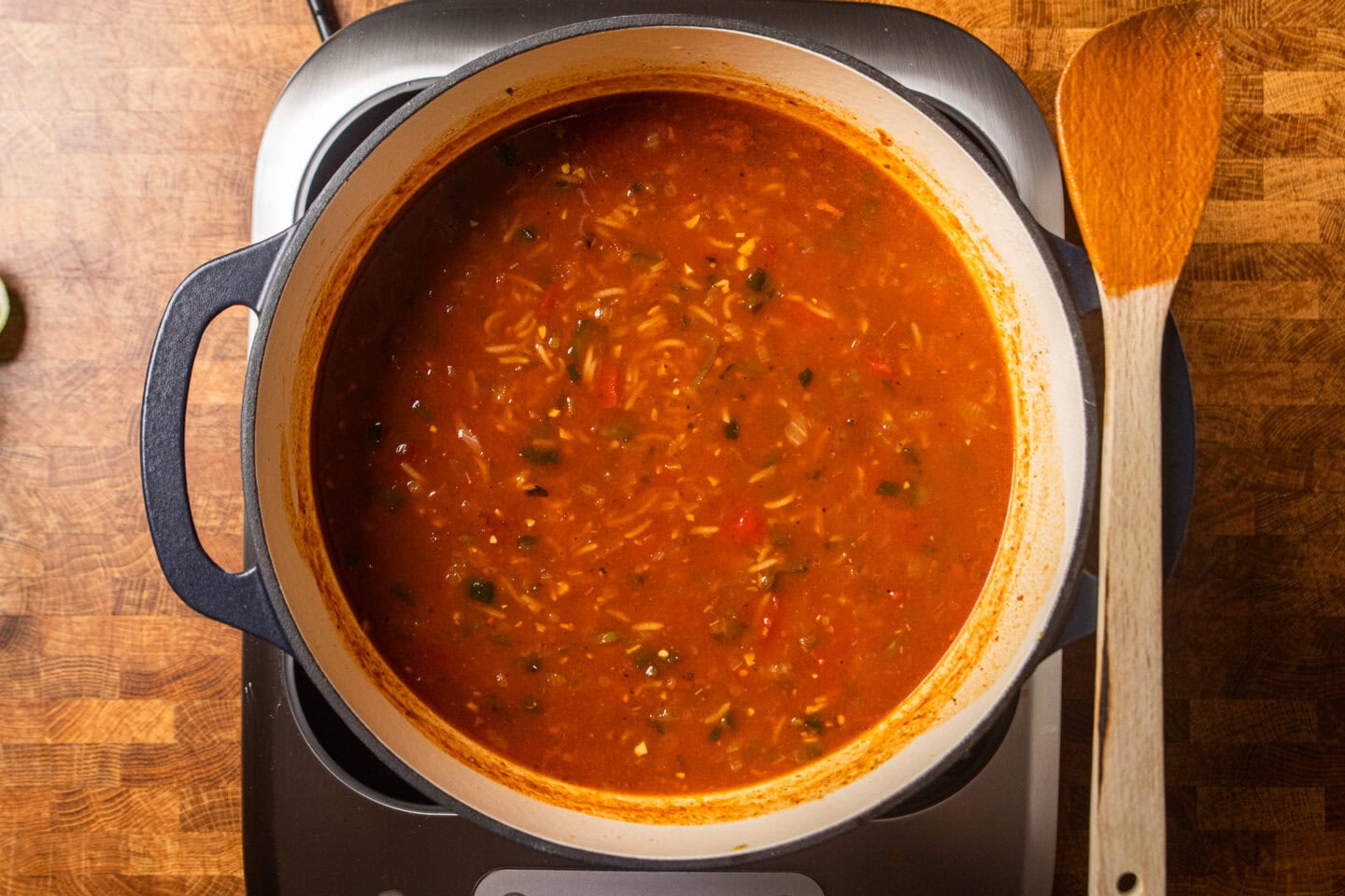 enchilada soup with rice added cooking in a dutch oven.