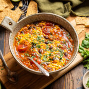 a bowl of black bean enchilada rice soup on a tablescape.