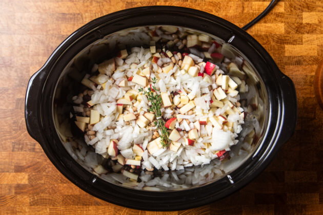 ingredients to make apple cider baked beans in a slow cooker uncooked.