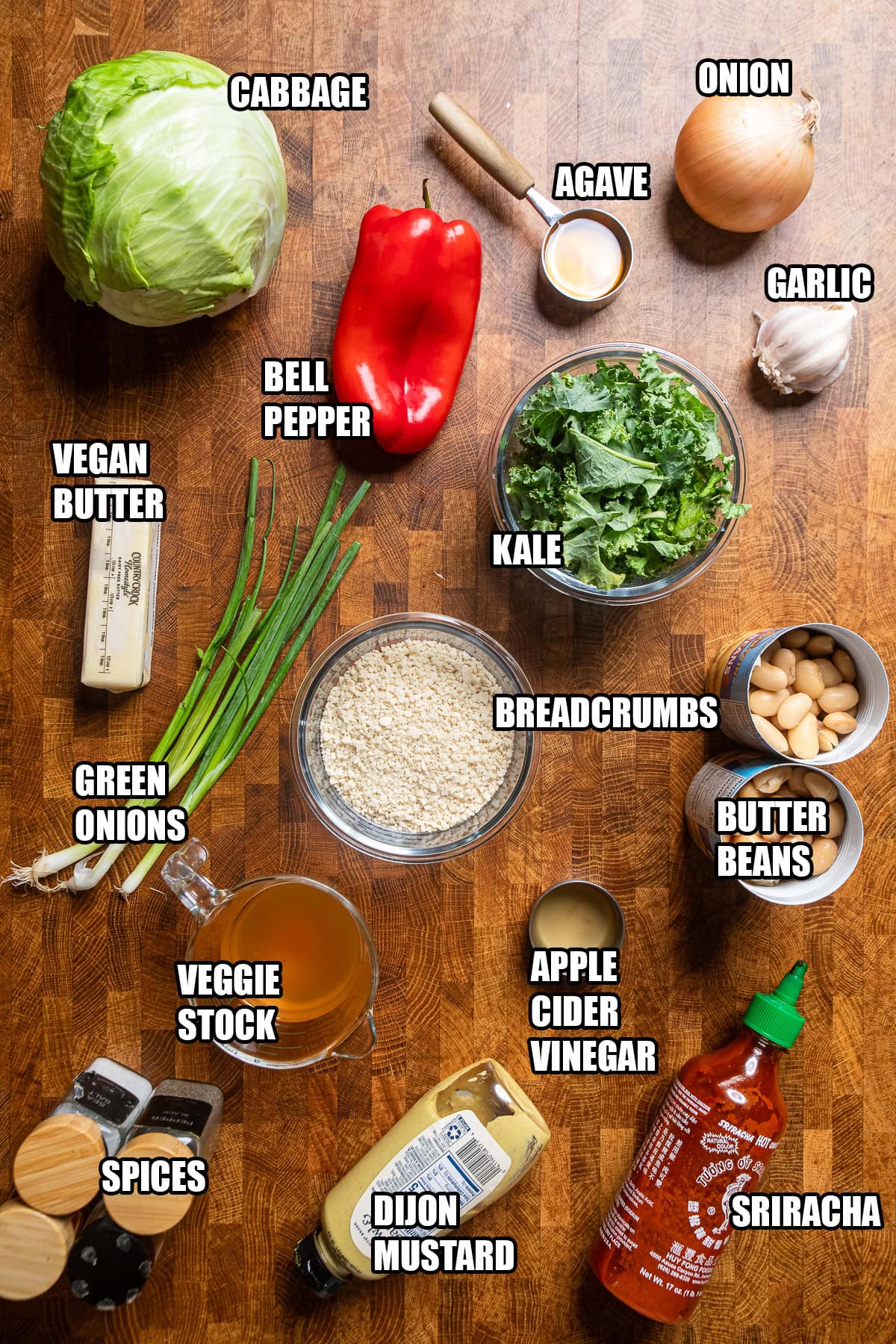 ingredients on a table to make a cabbage, pepper, kale and bean dish.