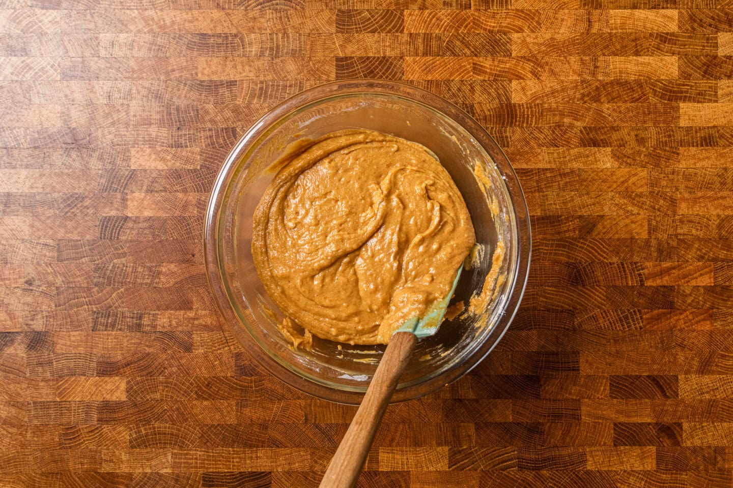 wet and dry pumpkin batter ingredients mixed together in a large glass bowl.