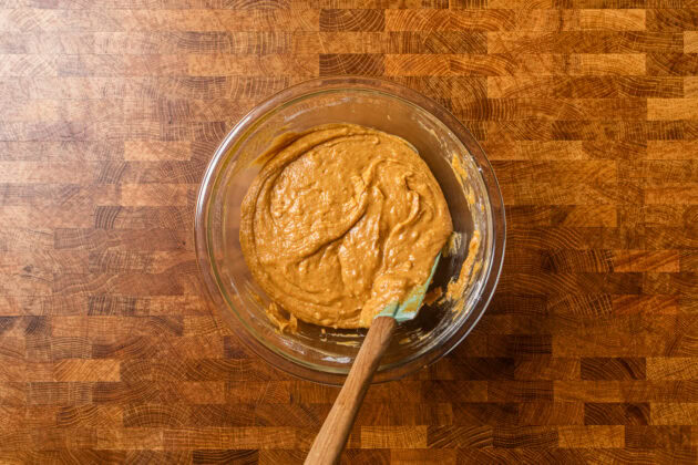 wet and dry pumpkin batter ingredients mixed together in a large glass bowl.