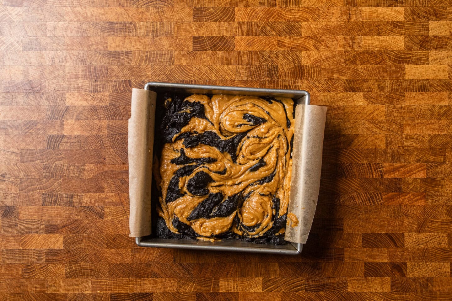 uncooked pumpkin swirl brownies in a baking dish.