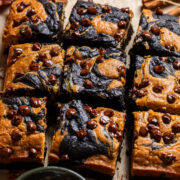 cut chocolate pumpkin swirl brownies with chocolate chips on top.