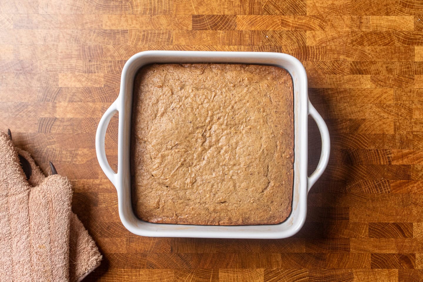 cooked toffee pudding batter on a table before spreading the toffee sauce.