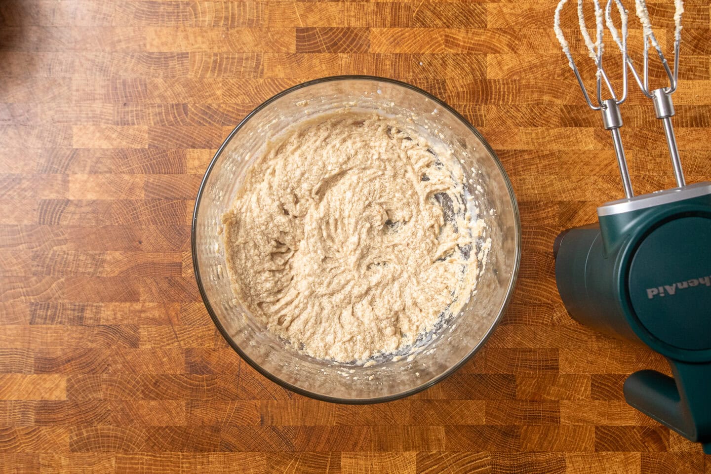 butter and sugar blended together in a glass bowl.