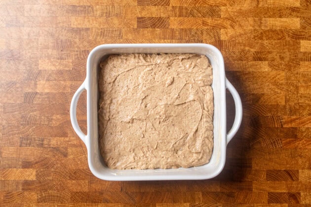 uncooked toffee pudding batter inside a white 8x8 baking dish.